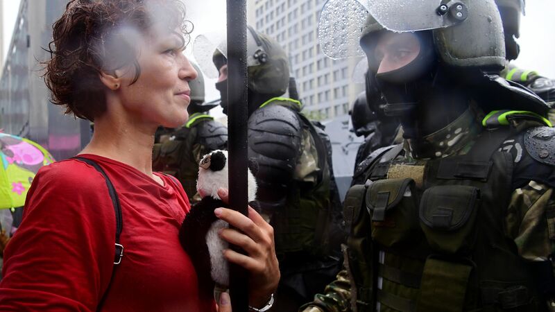 Участница несанкционированной акции оппозиции "Марш единства" и сотрудник милиции на одной из улиц в Минске - Rossiya Segodnya, 800, 14.09.2021
